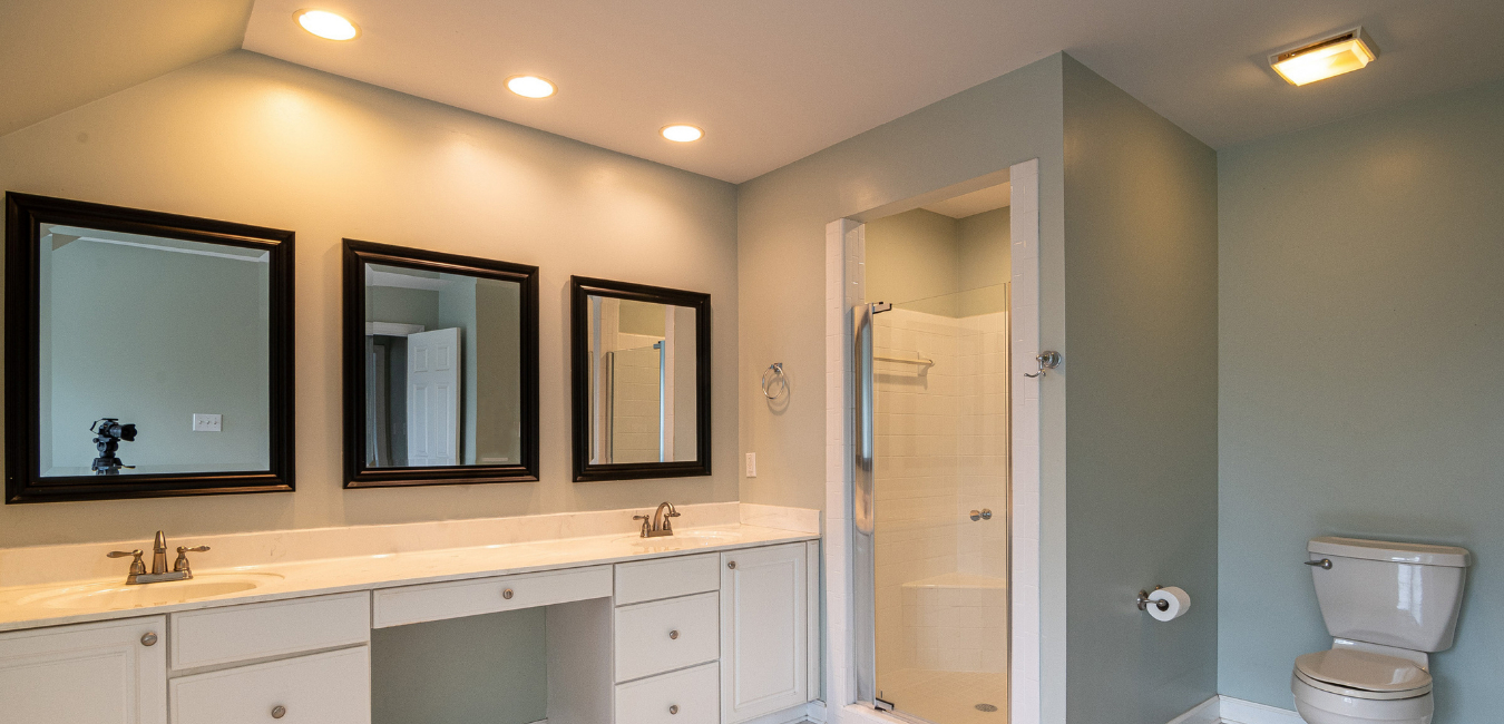 Beautiful White and Bright Bathroom in New Luxury Home Features Sink, and Square Mirrors. Shows Walk-in Shower.