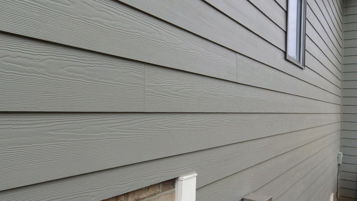 A before-and-after image of a house with faded siding compared to the same house with restored or replaced siding, showcasing the difference in appearance and the benefits of addressing fading.